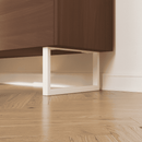 Nahaufnahme: Möbelfüße GRAZ in Weiß, 15 cm hoch, montiert unter einem Sideboard mit Holzfront