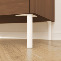 Nahaufnahme: Möbelfüße LINZ in Weiß aus 25 mm Rundrohr, montiert unter einem Sideboard mit Holzfront